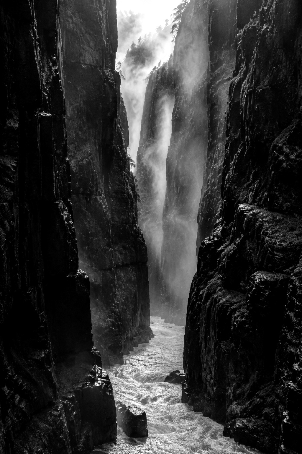 AI generated monochrome fine-art landscape of a rain-dark canyon and rising mist.